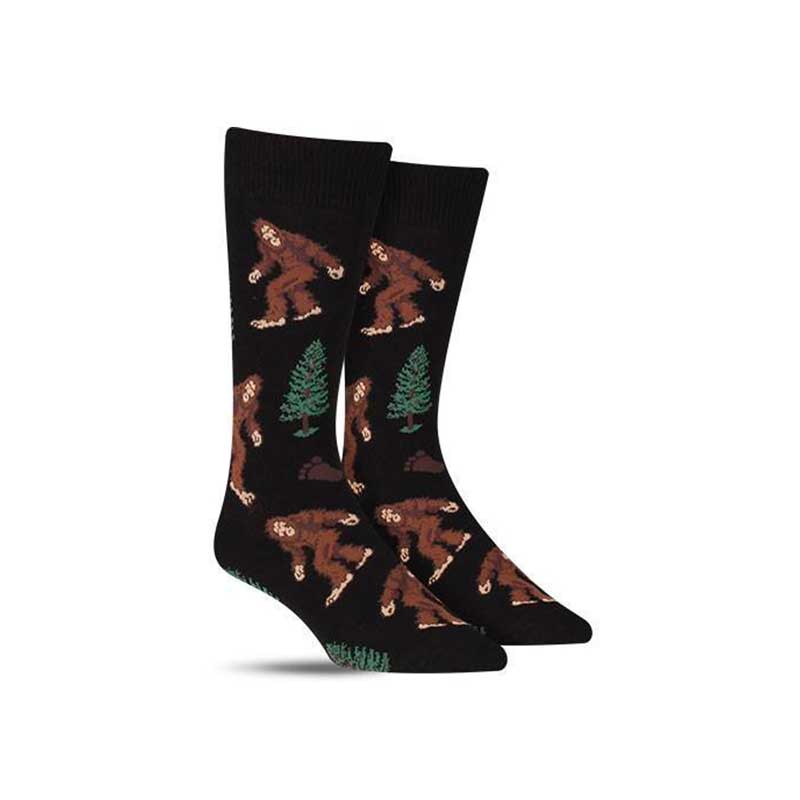Cool men's Bigfoot socks with Sasquatch walking through pine trees