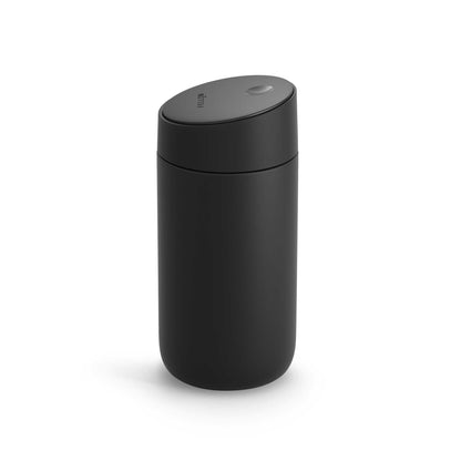 Double-walled travel mug with an angled lid, opened with the user’s thumb