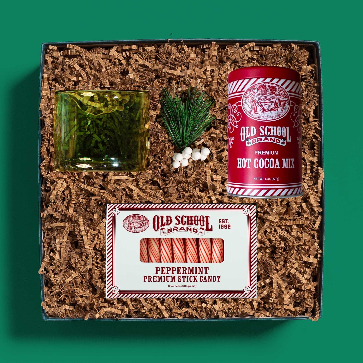 Corporate holiday gift box with a glass mug, hot cocoa mix and peppermint sticks