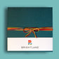 textured, teal gift box wrapped in colorful yarn and a belly band featuring the Brightlane logo