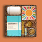 Upscale, curated gift box from Brightlane with lip balm, a travel mug, custom tote and more, all in sunshiny colors