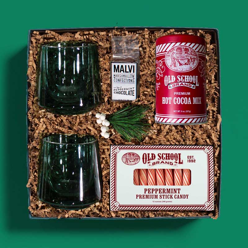 Gourmet holiday gift box with hot cocoa mix, peppermint candy, glass mugs and more
