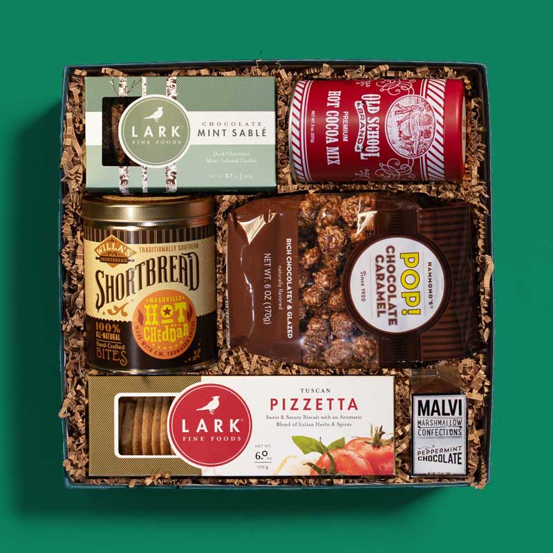 Food-lover’s holiday gift box with a variety of snacks and hot cocoa 