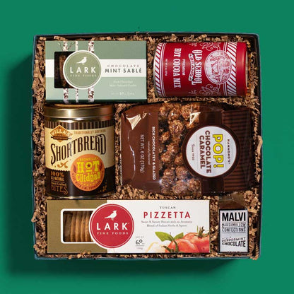 Food-lover’s holiday gift box with a variety of snacks and hot cocoa 