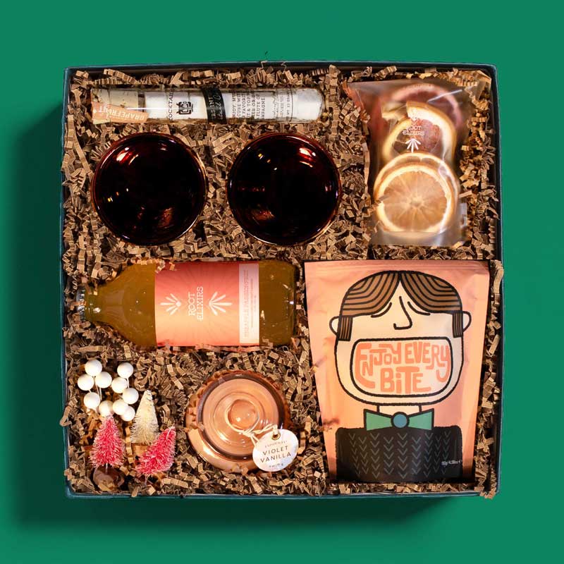 Fun and festive holiday gift box with cocktail mixer, garnish, glasses and more
