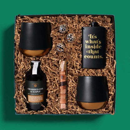 Festive holiday gift box with ingredients to make classic cocktails, plus glasses and a flask