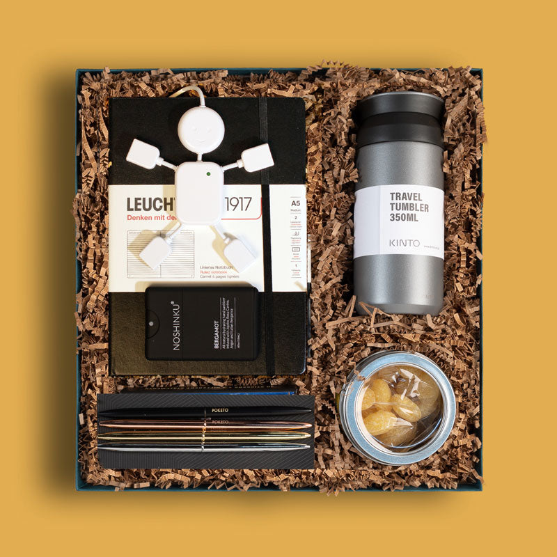 Curated corporate gift box from Brightlane with office supplies, hand sanitizer and a travel tumbler